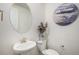 Stylish powder room features a sleek pedestal sink, modern fixtures, and decorative artwork at 2906 E 163Rd Ave, Thornton, CO 80602