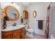 Elegant bathroom features oval mirror, wood vanity, and decorative wall accents at 11707 W 65Th Cir, Arvada, CO 80004