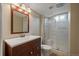 Clean bathroom with a shower, white vanity, and modern wood accents at 11707 W 65Th Cir, Arvada, CO 80004