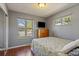 Cozy bedroom with hardwood floors, natural light, and neutral gray walls at 11707 W 65Th Cir, Arvada, CO 80004