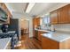 Efficient kitchen with stainless steel appliances, white countertops, and wood floors at 11707 W 65Th Cir, Arvada, CO 80004