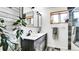 Modern bathroom with double sink vanity, decorative mirror, unique wood floor, and natural light at 30273 Conifer Rd, Evergreen, CO 80439