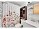 Bright bathroom featuring a floral shower curtain, under sink storage and a linen closet at 30273 Conifer Rd, Evergreen, CO 80439