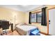 Bedroom with a window, desk, lamp, wooden floors, and neutral paint at 30273 Conifer Rd, Evergreen, CO 80439