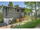 Two-story home exterior with a garden, a wooden deck, a garage, and greenery in a sunny, mountainous region at 30273 Conifer Rd, Evergreen, CO 80439