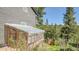 Exterior side view featuring a greenhouse, natural landscaping, and mature trees at 30273 Conifer Rd, Evergreen, CO 80439