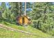 Exterior of barrel sauna in a wooded area with a small house in the background at 30273 Conifer Rd, Evergreen, CO 80439