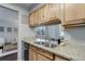 Kitchen sink features granite countertops, wood cabinetry, and stainless steel fixtures at 5873 S Prince St # 117C, Littleton, CO 80120