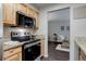 Well-lit kitchen featuring stainless steel appliances, wood cabinetry, and granite countertops at 5873 S Prince St # 117C, Littleton, CO 80120