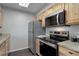 Modern kitchen with stainless steel appliances, granite countertops, and ample cabinet space for storage at 5873 S Prince St # 117C, Littleton, CO 80120