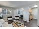 Modern living room featuring wood flooring, comfortable seating, and access to a kitchen and dining area at 5873 S Prince St # 117C, Littleton, CO 80120