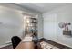 This office space has a dark wooden desk with an industrial bookshelf and dark-colored floors at 5873 S Prince St # 117C, Littleton, CO 80120