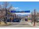 A street view of Littleton with historic buildings, 'Visit Littleton' banners, cars, and mountain views at 5873 S Prince St # 117C, Littleton, CO 80120