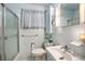 Functional bathroom with a shower, toilet, and sink, featuring blue tile and essential fixtures at 390 Yates St, Denver, CO 80219