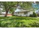 Single-story home featuring a well-kept lawn, walkway, and tidy landscaping at 390 Yates St, Denver, CO 80219
