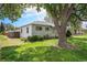 Charming single-story home with a well-maintained lawn, mature tree and light-colored siding at 390 Yates St, Denver, CO 80219