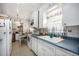 Functional kitchen with white cabinets, blue countertops, and vintage-style flooring at 390 Yates St, Denver, CO 80219