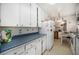 Bright kitchen with white cabinets, blue countertops, and vintage-style flooring at 390 Yates St, Denver, CO 80219