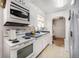Compact kitchen featuring white appliances and blue countertops with vintage appeal at 390 Yates St, Denver, CO 80219