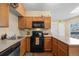 Well-lit kitchen features wood cabinets and a black oven at 5550 W 80Th Pl # 23, Arvada, CO 80003