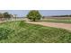 Spacious backyard with a tree and a basketball court with white fencing in the distance at 12745 Uinta St, Brighton, CO 80602