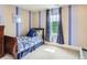 Well-lit bedroom featuring striped walls, large window, and a comfortable twin bed with blue bedding at 12745 Uinta St, Brighton, CO 80602