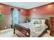 Inviting bedroom with red walls, decorative wainscoting, and queen bed with patterned bedding at 12745 Uinta St, Brighton, CO 80602