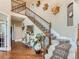 Grand foyer featuring a staircase with decorative iron railings and hardwood flooring, creating an elegant entry at 12745 Uinta St, Brighton, CO 80602