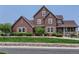 Charming two-story home featuring a manicured lawn, inviting front porch, and classic architectural details at 12745 Uinta St, Brighton, CO 80602