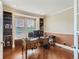 Well-lit home office with built-in shelves, a spacious desk, and large windows, creating a productive workspace at 12745 Uinta St, Brighton, CO 80602
