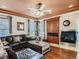 Inviting living room features a fireplace, hardwood floors, ceiling fan, and a large leather sectional sofa at 12745 Uinta St, Brighton, CO 80602