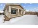 Covered patio and backyard with snow on the ground at 3254 Boral Owl Dr, Brighton, CO 80601