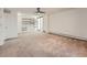 Carpeted living room with built-in shelves, a ceiling fan, and access to a balcony through sliding doors at 1250 N Humboldt St # 201, Denver, CO 80218