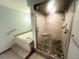 Modern bathroom featuring a luxurious jetted tub and a glass-enclosed shower with unique stone pebble floor at 7255 E Quincy Ave # 309, Denver, CO 80237