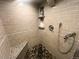 This tiled shower features a pebble floor, built-in shelves, and a modern shower head at 7255 E Quincy Ave # 309, Denver, CO 80237