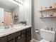 Well-lit bathroom featuring a large mirror and decorative shelving at 8199 Welby Rd # 1102, Denver, CO 80229