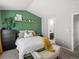 Bedroom has green accent wall and bench at 8199 Welby Rd # 1102, Denver, CO 80229