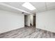 Bright basement featuring hardwood-style flooring, drop ceiling lighting, and convenient access to the stairs at 4274 S Fundy Way, Aurora, CO 80013