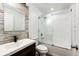 Updated bathroom featuring decorative wood-look accents, glass-enclosed tub, and modern fixtures at 4274 S Fundy Way, Aurora, CO 80013