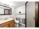 Bathroom with shower stall, wood panel accent wall, and standard vanity with a mirror at 4274 S Fundy Way, Aurora, CO 80013