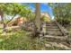 Backyard featuring stone retaining wall, stairs, and mature trees at 797 W Briarwood Ave, Littleton, CO 80120