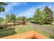 Spacious, grassy backyard enclosed by a wood fence, shaded by mature trees at 797 W Briarwood Ave, Littleton, CO 80120