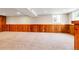 Spacious basement features carpet and wood paneling, ideal for a recreation room or additional living space at 797 W Briarwood Ave, Littleton, CO 80120