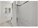 Clean white tiled bathroom with a shower-tub combo and natural light at 797 W Briarwood Ave, Littleton, CO 80120