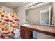 Bathroom features a vanity with a sink, toilet, and shower with patterned curtain at 20414 E 55Th Pl, Denver, CO 80249