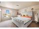 Comfortable bedroom featuring a large window and plush gray, tufted, king-sized bed at 20414 E 55Th Pl, Denver, CO 80249