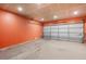 Unfinished garage interior with a new insulated white garage door and exposed overhead lighting at 20414 E 55Th Pl, Denver, CO 80249