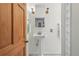 Bright bathroom with a charming pedestal sink, vintage-style lighting, and a wooden door at 2955 N Columbine St, Denver, CO 80205