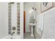 Bright bathroom with a shower featuring a glass block window and a charming pedestal sink with vintage-style lighting at 2955 N Columbine St, Denver, CO 80205