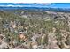 Breathtaking aerial view of a home nestled within a lush forest with snow-capped mountains in the background at 33 L Rd, Golden, CO 80403